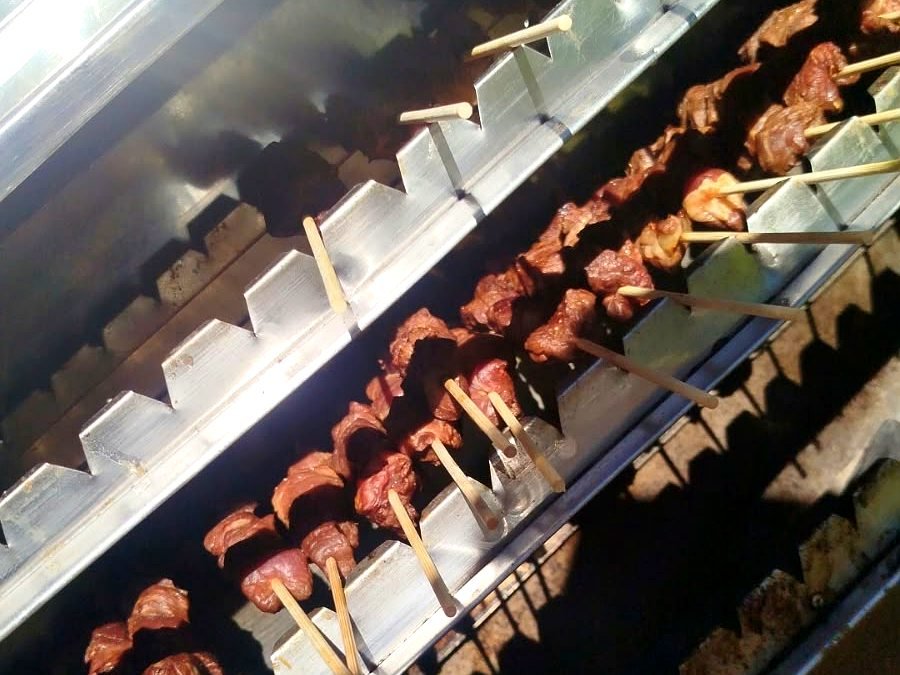 Espetinhos de churrasco na churrasqueira durante um evento