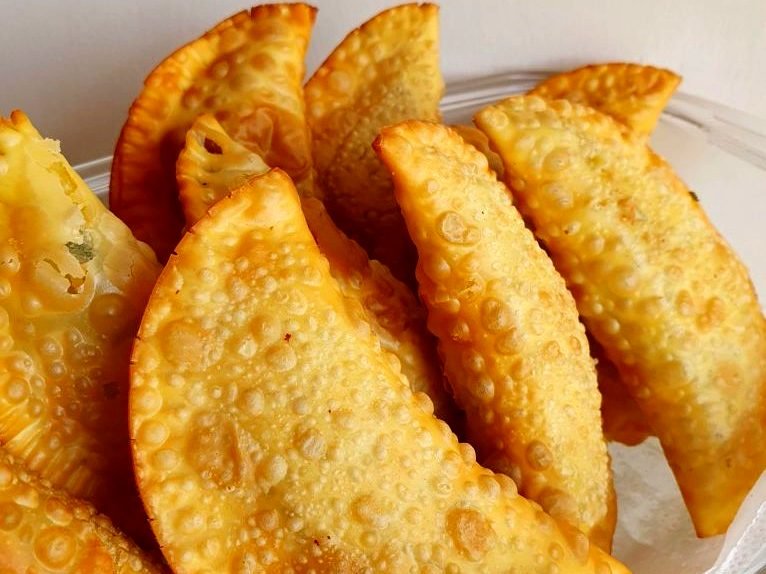 Pastéis meia lua fritos, servidos em uma festa