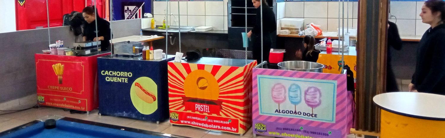 Barraquinhas de crepe, cachorro-quente, pastel e algodao doce montadas com a equipe uniformizada